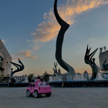 Girl with pink Cadillac at sunset